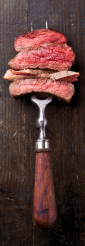 Sliced steak on a carving fork